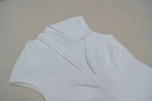 Détail de la robe bandage blanche avec tissu texturé et fermeture éclair invisible