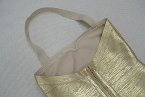 Détail du col licou doré et de la texture métallique sur une robe bandage de soirée chic