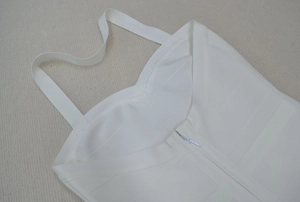 Gros plan sur la texture de la robe bandage blanche avec col en V et fermeture éclair