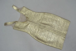 Detail of gold bandage dress showing back zipper closure and textured metallic surface