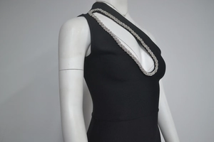 Détail de robe bandage noire avec décolleté ajouré et bordure en strass argentés