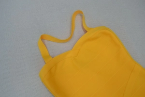Gros plan sur le tissu jaune du vêtement bandage montrant la texture côtelée et les coutures