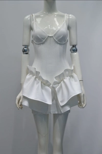 Detail of white bandage dress showing structured cups and sculptural ruffle hem design