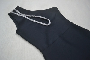 Détail d'une robe de soirée noire moulante avec col orné de strass argentés brillants