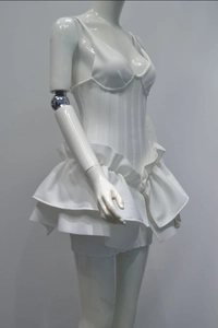 Detail of white corset strap dress featuring elegant double layered ruffle hem and slim fit