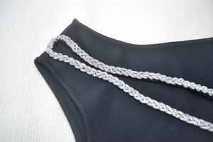 Gros plan des bretelles tressées en perles argentées sur une élégante robe de soirée noire