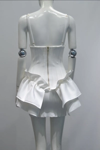 Close-up of back gold zipper and multi-layer ruffles on this white bandage dress