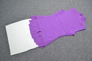 Detailed flat lay of a purple sleeveless bandage dress with layered fringe hemline