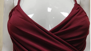 Détail de la robe en tulle bordeaux montrant le col en V croisé et la texture