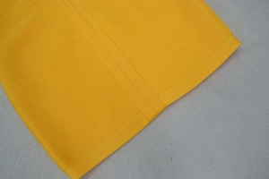 Gros plan sur le tissu jaune vif de la robe bandage avec coutures et texture