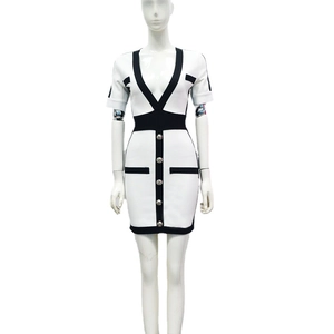 Mini robe bandage blanche élégante avec bordures noires contrastées et boutons dorés