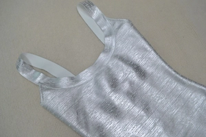Detailed macro shot of silver metallic fabric texture with shimmering finish on vest