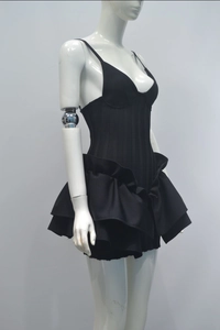 Detail of corset-style black dress featuring tiered ruffle skirt and thin straps