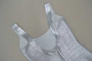 Detail view of silver metallic dress showing the invisible back zipper and foil texture