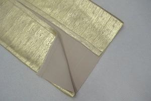 Détail du tissu à revêtement métallique doré avec envers tricoté pour robe bandage