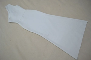 Détail d'une robe longue blanche à une épaule montrant le tissu lisse et le zip latéral