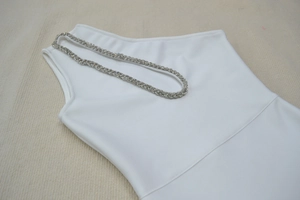 Détail de décoration en corde strassée argentée sur robe bandage blanche à une épaule