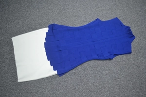 Close-up of royal blue bandage knit bodice with contrast white skirt fabric texture