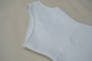 Détail de la robe bandage blanche montrant la fermeture éclair invisible et la texture