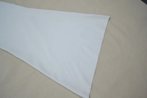 Détail des manches évasées en cloche sur un tissu de robe de soirée blanche de qualité