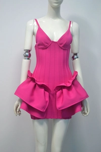 Close-up of fuchsia mini dress featuring corset structure and layered ruffle side details