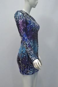 Close-up of shimmering gradient purple and blue sequins on a slim fit long sleeve dress