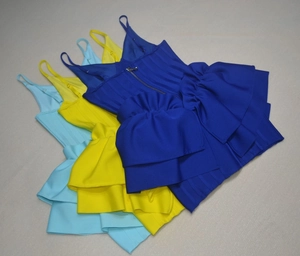 Detail of adjustable straps and tiered ruffle layers on a tight bandage mini dress