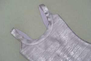 Détail du tissu rose métallique texturé de la robe bandage avec reflets argentés
