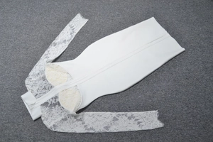 Détail des manches en dentelle blanche et fermeture éclair invisible sur robe de soirée