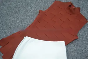 Detail of knit brick red high-neck top with textured squares and white A-line skirt