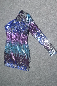 Flat lay of single shoulder sequin dress with multi-color gradient and long sleeve detail