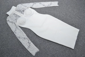 Détail de robe blanche en dentelle montrant le motif floral et la fermeture éclair au dos