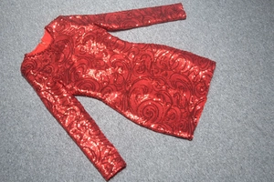 Vue détaillée des paillettes rouges et des motifs tourbillonnants sur la robe courte