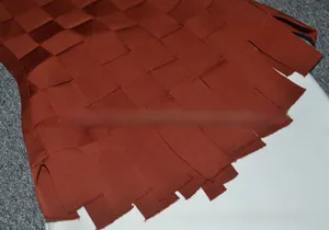 Close-up of dark red woven fabric detail with crisscross ribbon texture and fringe edge