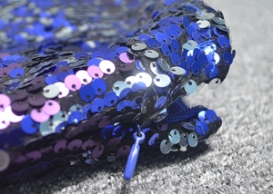 Detailed close-up of blue sequin fabric with matching invisible zipper on evening dress