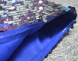 Close-up of purple and blue sequins with shiny blue ribbed knit lining on evening dress