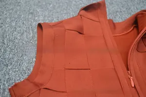 Detail of burnt orange bandage fabric with cross-woven texture and invisible side zipper