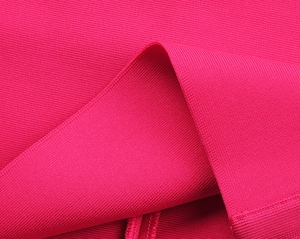 Dettaglio macro del tessuto fucsia elasticizzato con trama a maglia orizzontale fitta