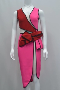 Detail of color-block bandage dress with asymmetric cut and red sculptural waist bow