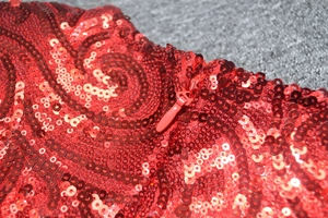 Détail de robe de soirée à paillettes rouges avec fermeture éclair et texture spirale