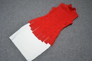 Close-up of a French style red bandage turtleneck top paired with a white A-line skirt