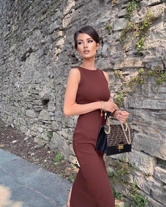 Detail of a brown ribbed knit midi dress with side slit and designer chain handbag