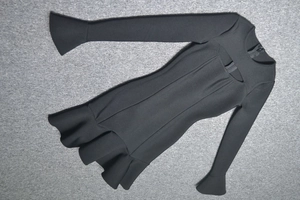 Détail de la robe noire sexy avec découpe, manches évasées et finitions à volants