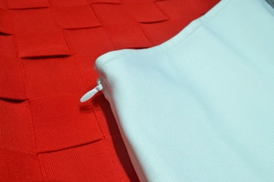 Macro view of seamless invisible zipper and fine knit texture on white dress
