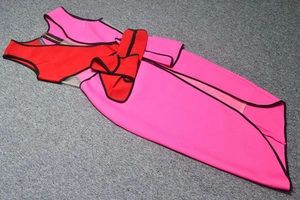 Flat lay of pink and red bandage dress featuring tiered ruffles and gold back zipper