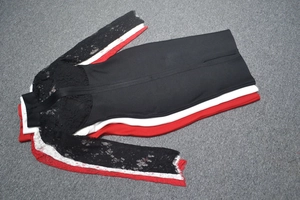 Détail des manches en dentelle sur robe moulante en noir, blanc et rouge élégant