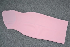 Abito aderente rosa senza maniche steso in piano, tessuto strutturato e vestibilità slim
