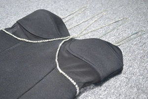 Dettaglio abito da sera in mesh nero con spalline a catena di diamanti e strass lucidi