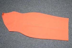 Abito a fascia aderente arancione brillante con spalline sottili su sfondo grigio testurizzato