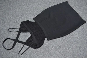Détail de la texture en maille évidée et fine bretelle sur cette mini robe bandage noire